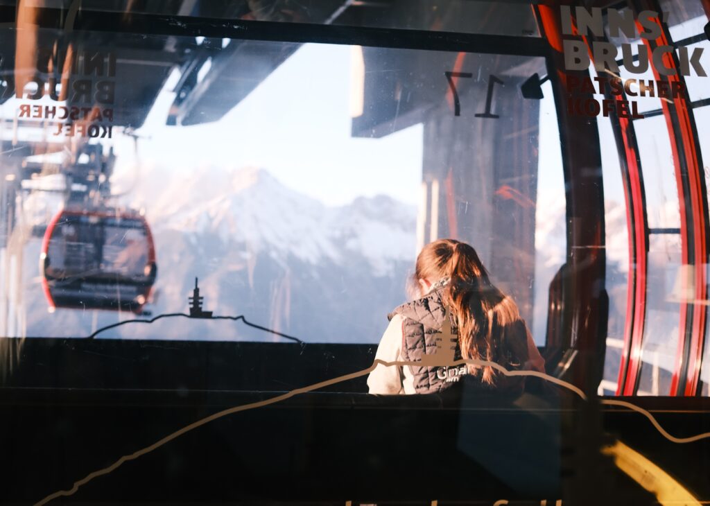 Familienfreundliche Skigebiete bei Innsbruck - eine Frau sitzt auf einem Sessellift