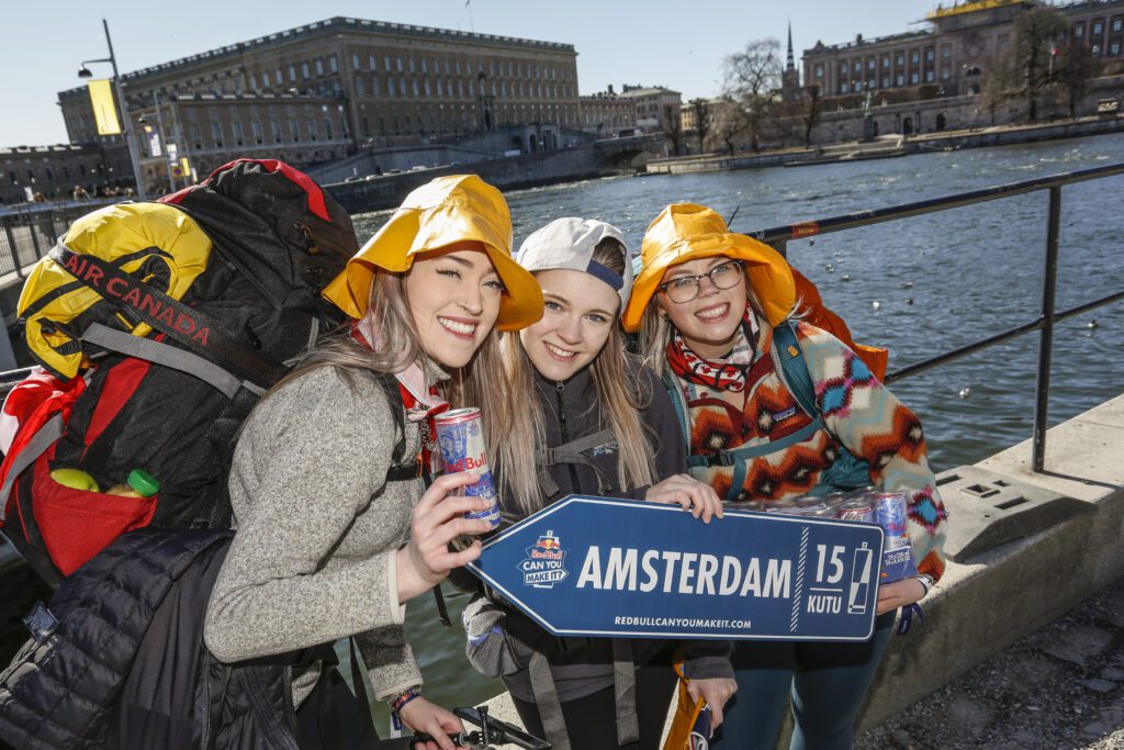 🔥 Befreie deinen inneren Wegbereiter 🔥 - drei Teilnehmer posieren vor einem Fluss und zeigen ein Zeichen nach Amsterdam  