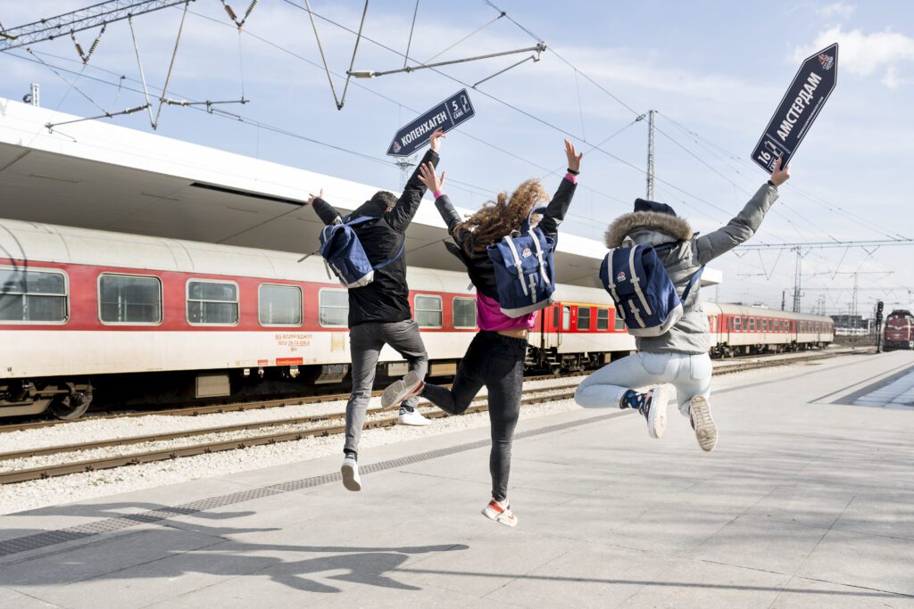 🔥 Befreie deinen inneren Wegbereiter 🔥 - drei Teilnehmer von hinten gesehen, die auf einem Bahnhof springen
