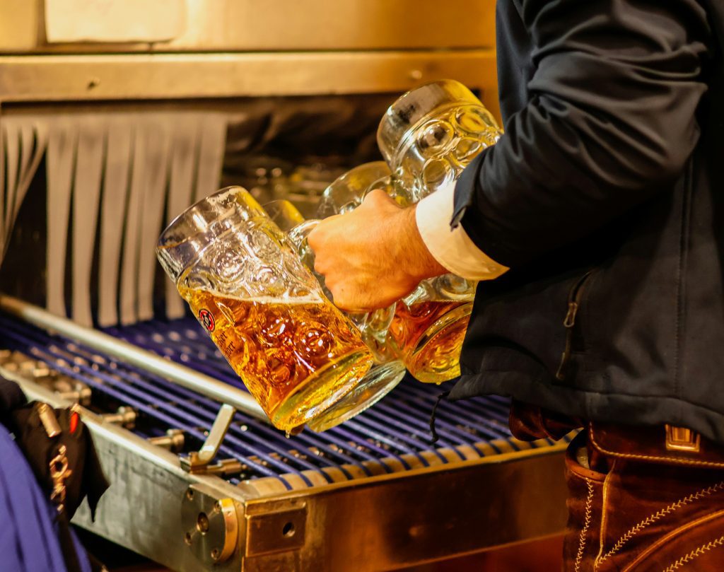 Munich Oktoberfest: the hand of a man holding 3 glasses of beers