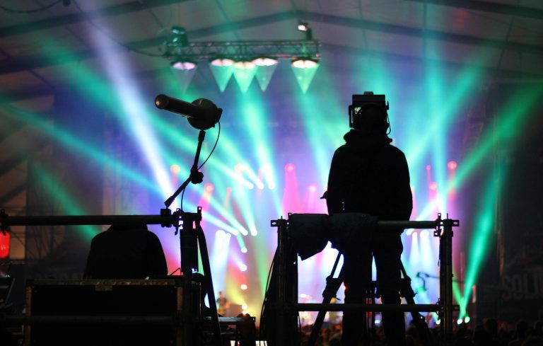 Berlin concerts 2024: a man on the stage with colourful lights shaping his silhouette