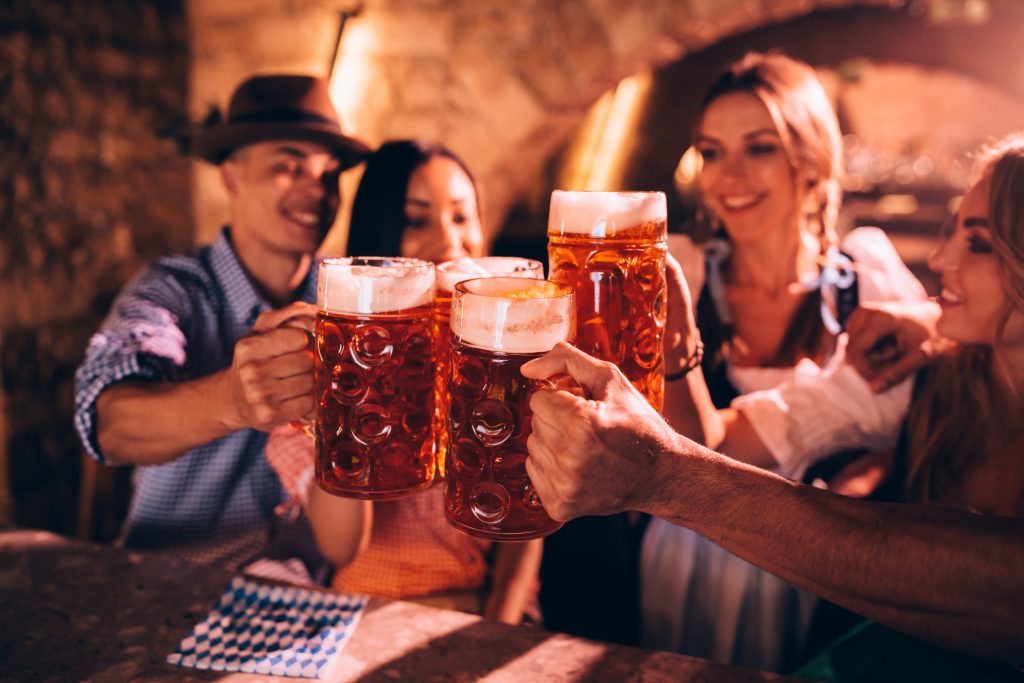 Facts about Munich: people in Bavarian clothing cheering with beer