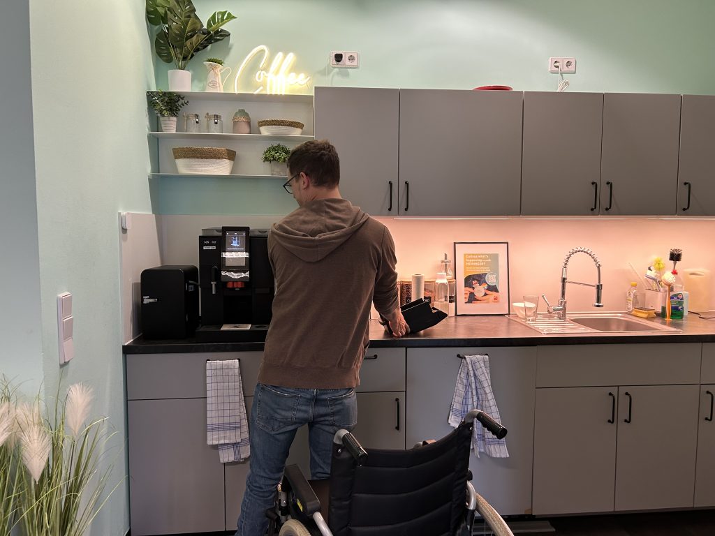 Nico macht die Kaffeemaschine in der Küche des MEININGER Hotels HQ bereit