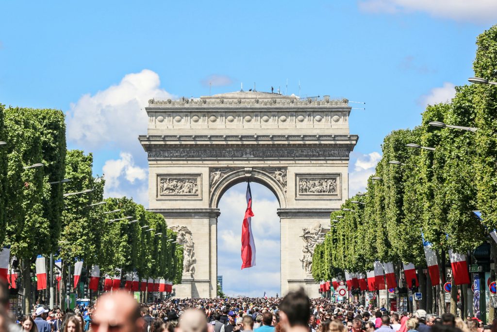 Jours fériés 2025 France: l’Arc de Triomphe décoré de drapeaux français lors des célébrations de la Fête nationale.