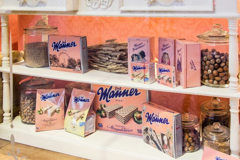 Manner wafers and vintage packaging displayed on a pastel-colored shop shelf.