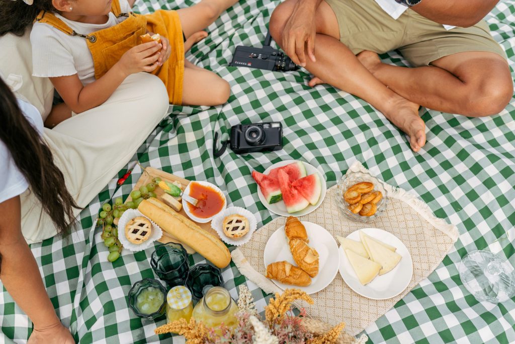 Italien Feiertage: eine Familie, die während Pasquetta ein Picknick auf einer karierten Tischdecke genießt.