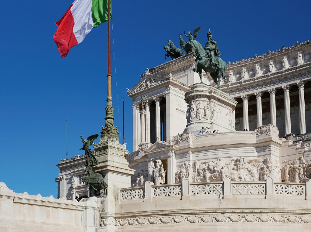 Italien Feiertage: das Victor-Emmanuel-II-Denkmal in Rom und eine wehende italienische Flagge während der Feierlichkeiten zum Tag der Republik.