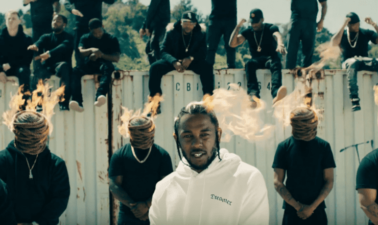 Concerts in Paris: Kendrick Lamar surrounded by performers with flaming heads during an outdoor music video shoot