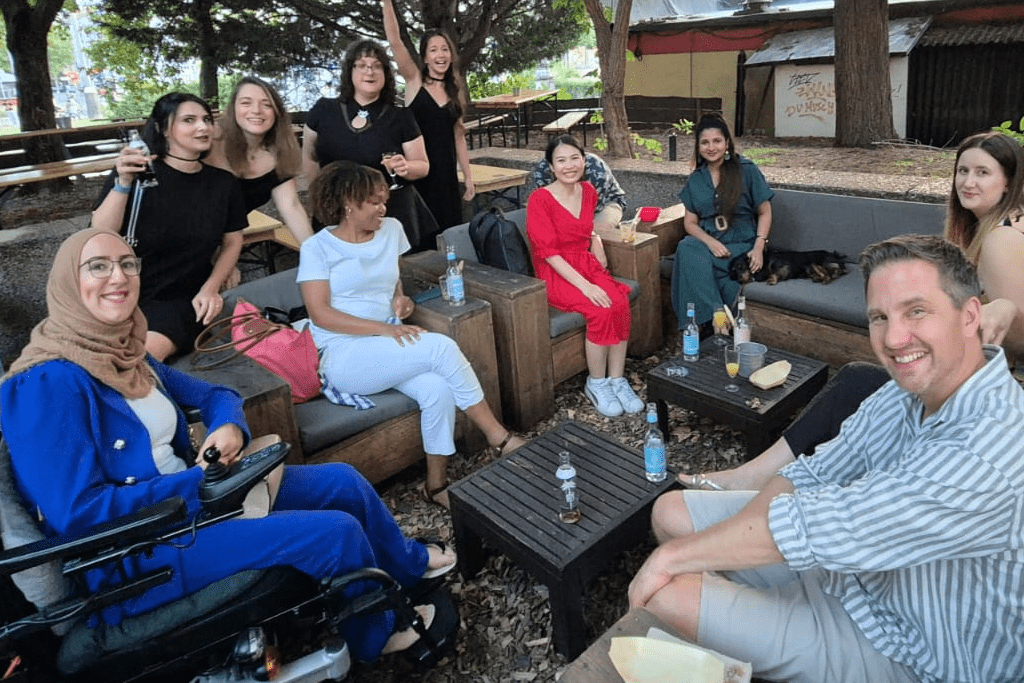 Majeda und ihr Team sitzen draußen und genießen ihre Drinks