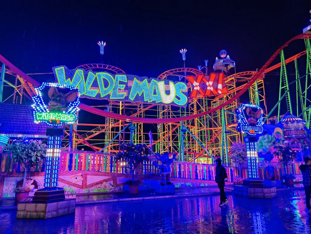 Hamburger DOM: die beleuchtete Wilde Maus XXL Achterbahn auf dem Hamburger DOM, strahlend in bunten Neonlichtern bei Nacht