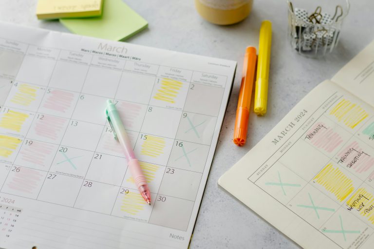 Organized desk with March 2024 calendars, colorful markers, and planning notes