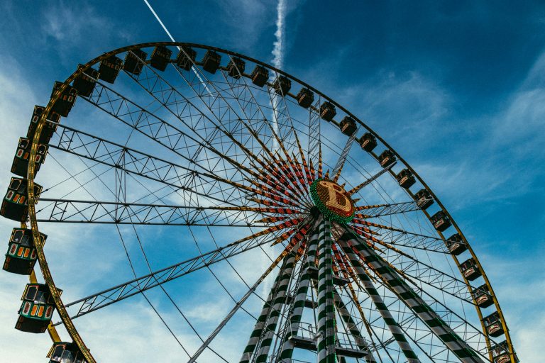 Large Ferris wheel towering against a blue sky with scattered clouds