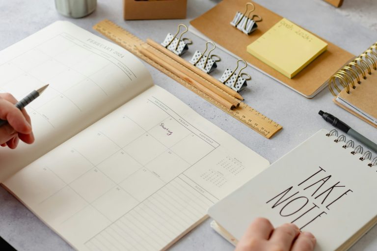 Organized desk with calendar, notebooks, and stationery essentials