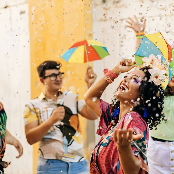 Guests celebrating with confetti and umbrellas at MEININGER Hotels, perfect for cultural trips