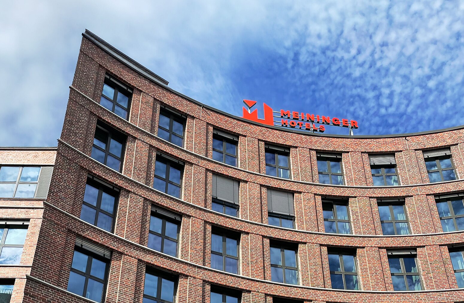 MEININGER Hotels building with a modern design and logo visible on the rooftop.